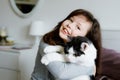 Cute adorable school kid girl cuddling and playing together with cat in bed in morning. Happy family, friendship between Royalty Free Stock Photo