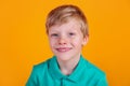 Cute adorable schoolboy wearing turquoise t-shirt on yellow background