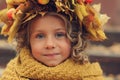 Cute adorable toddler girl portrait with bouquet of autumn leaves and wreath walking outdoor in park Royalty Free Stock Photo