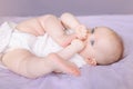 Cute adorable white Caucasian infant child girl boy with blue eyes lying on bed Royalty Free Stock Photo