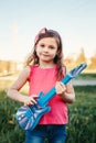 Cute adorable young girl playing guitar toy outdoor. Girl pretending to be a rock music star. Adorable funny child having fun in Royalty Free Stock Photo