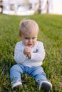 Cute and Adorable Young Toddler Baby Boy Playing in the Backyard Green Grass and Smiling at the Camera Royalty Free Stock Photo