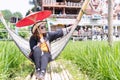 A cute adult Asian woman wears a straw hat and sunglasses holding a red paper umbrella handmade Royalty Free Stock Photo