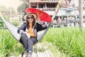 A cute adult Asian woman wears a straw hat and sunglasses holding a red paper umbrella handmade Royalty Free Stock Photo