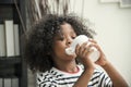 Cute African American boy drinking water from mug. Royalty Free Stock Photo