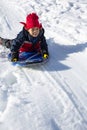 Cute African American boy sledding down the hill on a snowy day Royalty Free Stock Photo