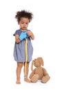 Cute African American child imagining herself as doctor while playing with stethoscope and toy bunny on white