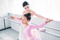 cute african american child in pink tutu exercising with teacher
