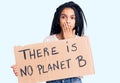 Cute african american girl holding there is no planet b banner covering mouth with hand, shocked and afraid for mistake Royalty Free Stock Photo