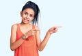 Cute african american girl wearing casual clothes pointing aside worried and nervous with both hands, concerned and surprised