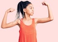 Cute african american girl wearing casual clothes showing arms muscles smiling proud Royalty Free Stock Photo