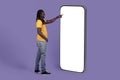 Cute african american guy using huge cell phone, mockup Royalty Free Stock Photo