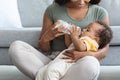 Black Infant Baby Drinking Water From Bottle While Relaxing On Mother& x27;s Laps Royalty Free Stock Photo