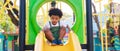 Cute African American little kid boy funny while playing on the playground in the daytime in the spring season. Outdoor activity. Royalty Free Stock Photo