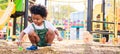 Cute African American little kid boy funny while playing on the playground in the daytime in the spring season. Outdoor activity. Royalty Free Stock Photo