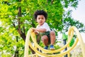 Cute African American little kid boy having fun while playing on the playground in the daytime in summer. Outdoor activity. Royalty Free Stock Photo