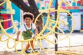 Cute African American little kid boy having fun while playing on the playground in the daytime in summer. Outdoor activity. Royalty Free Stock Photo