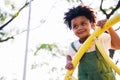 Cute African American little kid boy having fun while playing on the playground in the daytime in summer. Outdoor activity. Royalty Free Stock Photo