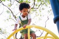 Cute African American little kid boy having fun while playing on the playground in the daytime in summer. Outdoor activity. Royalty Free Stock Photo