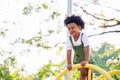 Cute African American little kid boy having fun while playing on the playground in the daytime in summer. Outdoor activity. Royalty Free Stock Photo