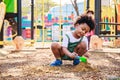 Cute African American little kid boy having fun while playing on the playground in the daytime in summer. Outdoor activity. Royalty Free Stock Photo