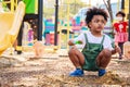 Cute African American little kid boy having fun while playing on the playground in the daytime in summer. Outdoor activity. Royalty Free Stock Photo