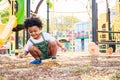 Cute African American little kid boy having fun while playing on the playground in the daytime in summer. Outdoor activity. Royalty Free Stock Photo