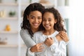 Cute african american school girl hugging her cheerful mother Royalty Free Stock Photo