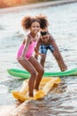 cute african american siblings standing on inflatable mattresses