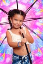 Cute african american small girl holding a huge colorful umbrell Royalty Free Stock Photo