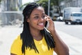 Cute african american woman in a yellow shirt at mobile phone Royalty Free Stock Photo