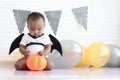 Cute African baby kid dressing up vampire fancy Halloween costume with black bat wings, cheerful little cute child holds Halloween Royalty Free Stock Photo