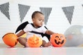 Cute African baby kid dressing up vampire fancy Halloween costume with black bat wings, cheerful little cute child holds Halloween Royalty Free Stock Photo