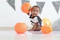 Cute African baby kid dressing up vampire fancy Halloween costume with black bat wings, cheerful little cute child holds Halloween Royalty Free Stock Photo