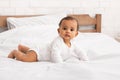 Cute African Baby Lying On Stomach Posing In Bedroom Indoors Royalty Free Stock Photo