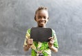 Cute African Black Girl Child in a School Uniform Holding Blackboard Sign with Copy Space as an Education School Symbol