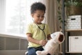 Cute african boy playing with toy as doctor holding stethoscope Royalty Free Stock Photo