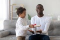 Cute african kid son giving gift to dad fathers day Royalty Free Stock Photo