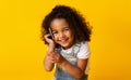 Cute afro girl talking on cellphone on yellow background Royalty Free Stock Photo