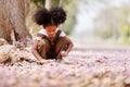 A cute Afro girls under flowering tree in park.