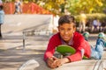 Cute Arabian boy laying on green skateboard