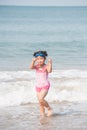 Cute asia girl having fun on the sunny tropical beach with wonderful waves around her. Royalty Free Stock Photo