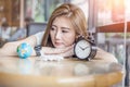 Cute asia girl looking to globe and alarm clock try to make dec Royalty Free Stock Photo