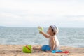 Cute Asian baby boy playing with beach toys on tropical beach and sea Royalty Free Stock Photo