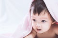 Cute asian baby girl smiling under pink blanket Royalty Free Stock Photo