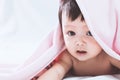 Cute asian baby girl smiling under pink blanket Royalty Free Stock Photo
