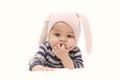 Cute Asian baby girl sucking finger with pink rabbit hat on white background.