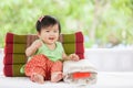 Cute asian baby girl in Thai traditon dress sitting with pillow Royalty Free Stock Photo