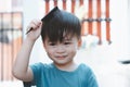 Cute Asian boy combing his hair at home