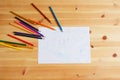 Cute Asian boy drawing happy family and home. with color pencils and white paper on wooden table, top view Royalty Free Stock Photo